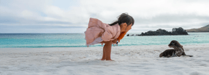 Child watching a sea lion pup on a beach in the Galapagos Islands during a family wildlife adventure.