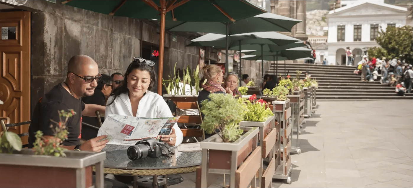Two travelers study a map as they relax at a café in Quito’s Historic Center, planning their next adventure.
