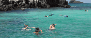 Devil's Crown - Floreana in the Galapagos Islands with tourist doing snorkeling and the crown in the background