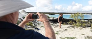 Cerro Brujo - San Cristobal in Galapagos Islands, tourist walking in the beach and watching the sea