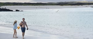 Cerro Brujo - San Cristobal in Galapagos Islands, tourist walking in the beach and watching the sea